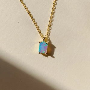 Macro detail of rectangle opal pendant on 18K gold plated stainless steel necklace chain