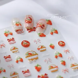 Macro shot of 3D embossed strawberry nail stickers with detailed red bows and lettering