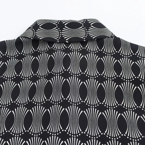Detailed view of the lapel collar and geometric pattern print on black blouse
