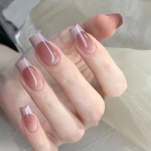 Detail of gradient pink French tip press-on nails in long trapezoid shape on hands