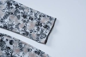 Detail shot showing the fine sewing process and floral pattern on the jumpsuit cuffs