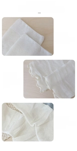 Detail view of white ballet-style leg warmers showing elastic cuff and mesh knit texture