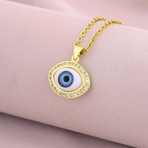Macro detail of gold 18K plated evil eye pendant with micro-set zircon crystals