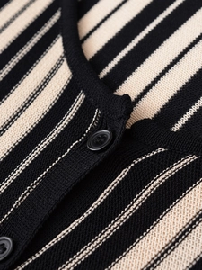 Macro detail of knit fabric texture with black and white stripes and round neckline button
