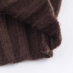 Close-up of retro color-block cable knit sweater showing dark brown ribbed wool texture