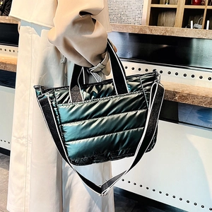 Detail of quilted puffer crossbody bag with glossy finish and woven shoulder strap