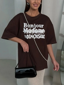 Close-up of white Bonjour Madame embroidery on a heavy cotton dark brown oversized t-shirt