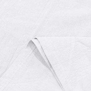Detail shot of white linen fabric with fine wrinkle texture and double-stitched sewing finish