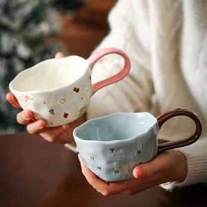 Detail view of two ceramic mugs with animal patterns and irregular textured surfaces