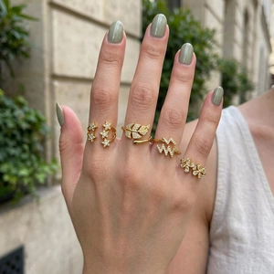 Detailed shot of five gold-tone rings featuring maple leaf and star zircon patterns