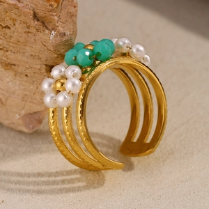 Détail d'une bague multicouche plaquée or 18K avec perles vertes et blanches sur pierre