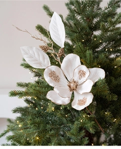 Close-up of elegant white and gold artificial magnolia branch on a Christmas tree