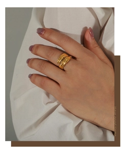 Detail of a double-layered gold feather ring in stainless steel worn on a model hand
