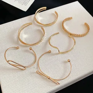 Set of 6 minimalist gold-plated open bangles in various textured and curved designs