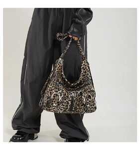 Detailed view of leopard print PU leather shoulder bag with functional front utility pockets