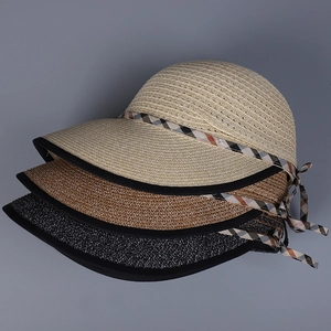 Detail of straw sun hats in beige, brown, and black with elegant plaid bow decoration