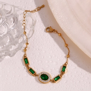 Macro detail of 18K gold-plated bracelet featuring green crystals and white zircon accents