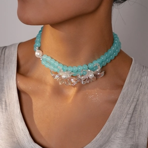 Detailed macro view of double-layered beaded necklace with translucent flower charms