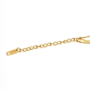 Detailed close-up of 18k gold plated stainless steel extension chain and small logo tag