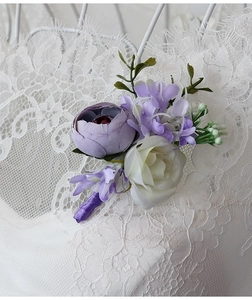 Detailed close-up of a purple boutonniere with white rose and violet ribbon wrap