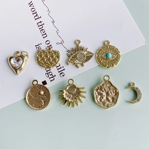 Set of gold alloy pendants with evil eye, moon, and heart designs featuring inset crystals