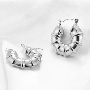 Minimalist silver U-shaped striped stainless steel hoop earrings on white silk fabric