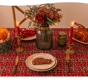 Detailed festive tablescape featuring a red and green plaid tablecloth with snowflake prints