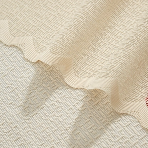 Close-up of cream lace curtain with scalloped edge and delicate mesh texture detail