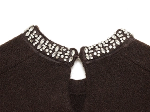 Detailed view of dark brown knitwear collar with crystal beading and keyhole design