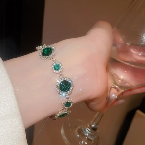 Details eines eleganten Silberarmbands mit runden grünen Edelsteinen am Handgelenk