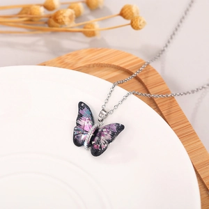 Detailed macro view of an acrylic butterfly necklace with purple and blue painted textures