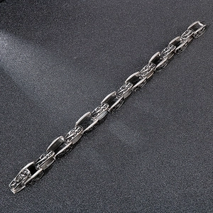 Detailed macro shot of vintage silver steel chain featuring gothic dagger embossed pattern