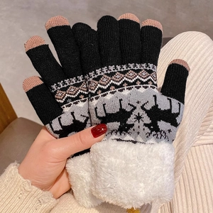 Detail von warmen Winter-Strickhandschuhen mit Rentier-Muster und Touchscreen-Funktion
