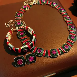 Vintage emerald and ruby style jewelry set with necklace and earrings on leather background