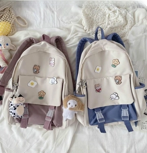 Detail of cute Harajuku style backpacks with cartoon patches and plush doll charms