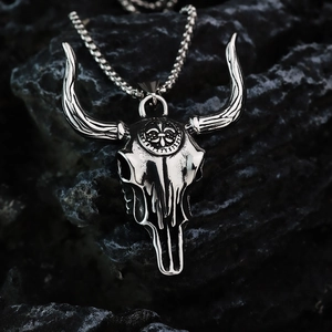 Vintage stainless steel bull head skull pendant with punk chain on dark rock background