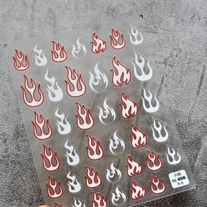 Makroansicht ultradünner roter und weißer Flammen-Nagelaufkleber auf Steinfläche