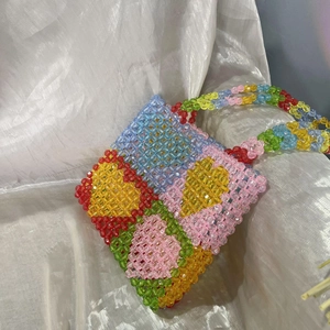 Detailed view of colorful acrylic beads and handmade weaving on a vibrant tote bag