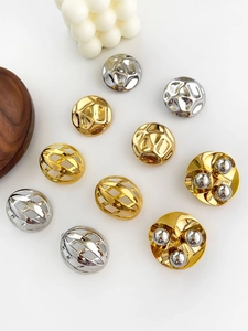 Flat lay of retro hammered and hollowed out semi-circle gold and silver metal earrings