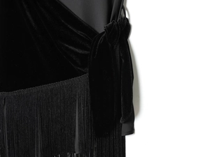 Detail of velvet dress showing side knot design and elegant black fringe trim details