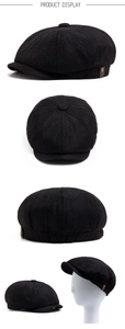Detail view of black linen-style octagonal cap with side leather trim and metal buckle