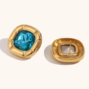Macro detail of square teal gemstone earrings with textured gold plated frames and back
