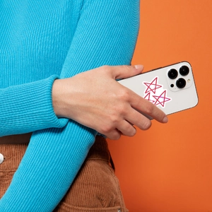 Close-up of decorative star heart stickers in red and pink on a white mobile phone