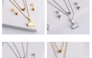 Detail of two-tone stainless steel jewelry set with crown pendant and spherical earrings