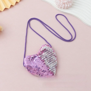 Macro shot of heart-shaped sequin mini bag with pink glitter and woven strap for kids