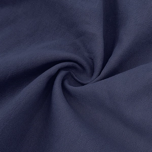 Close-up of deep blue linen fabric texture showing breathable plain weave and soft material