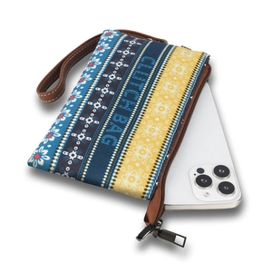 Detailed view of printed fabric clutch bag with wristlet showing phone storage capacity