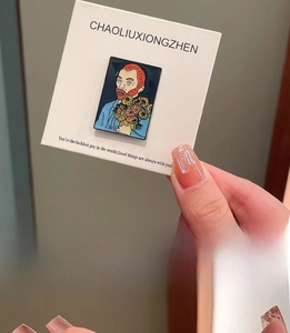 Detailed close-up of Van Gogh enamel pin with sunflower design held in hand