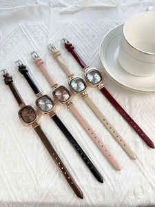 Detailed macro view of five vintage square leather strap quartz watches in assorted colors