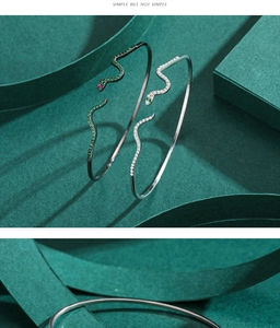 Detailansicht der schlangenförmigen Armspangen mit grünen und roten Edelsteinen